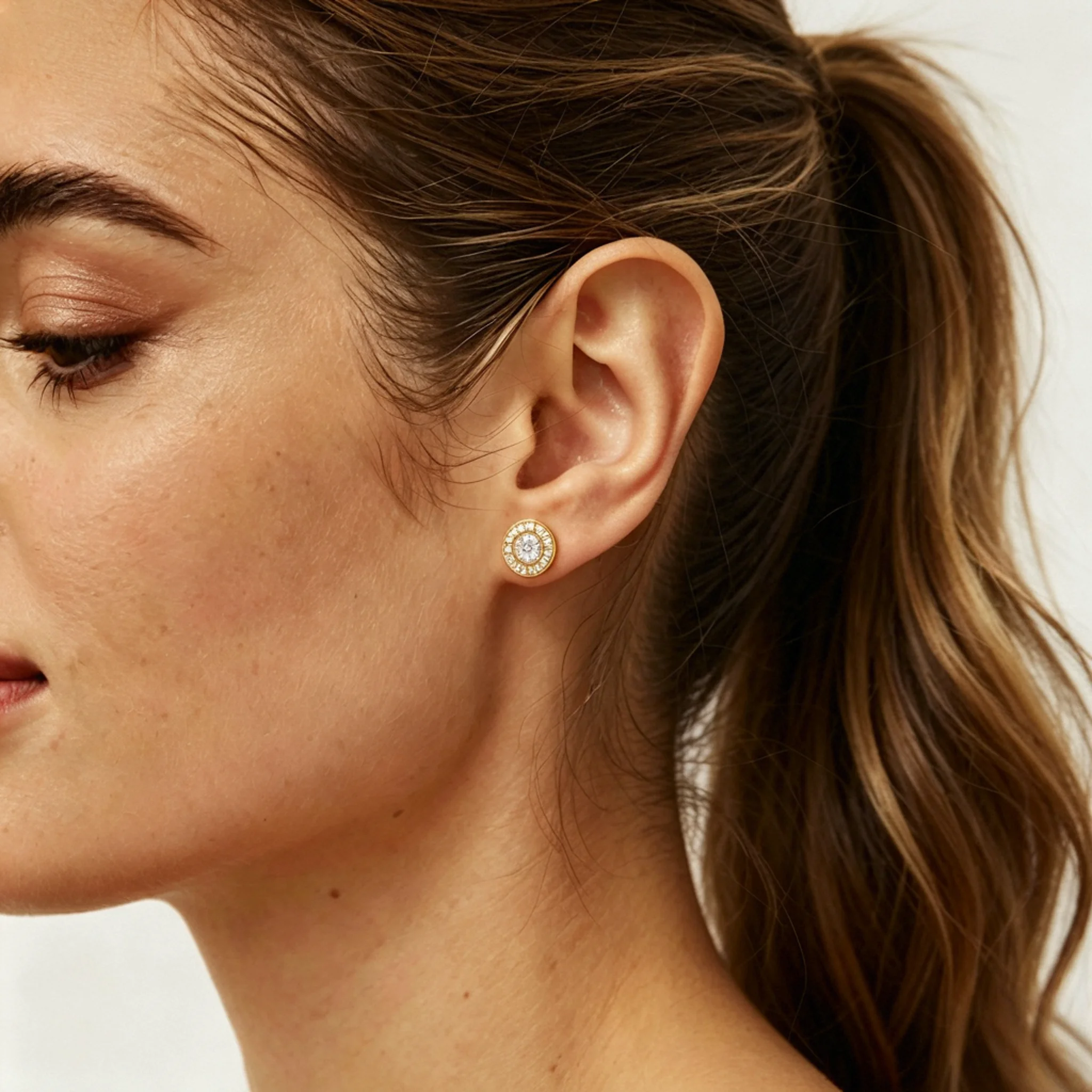 Diamond halo earrings shown on a model with center stone presence and ear scale