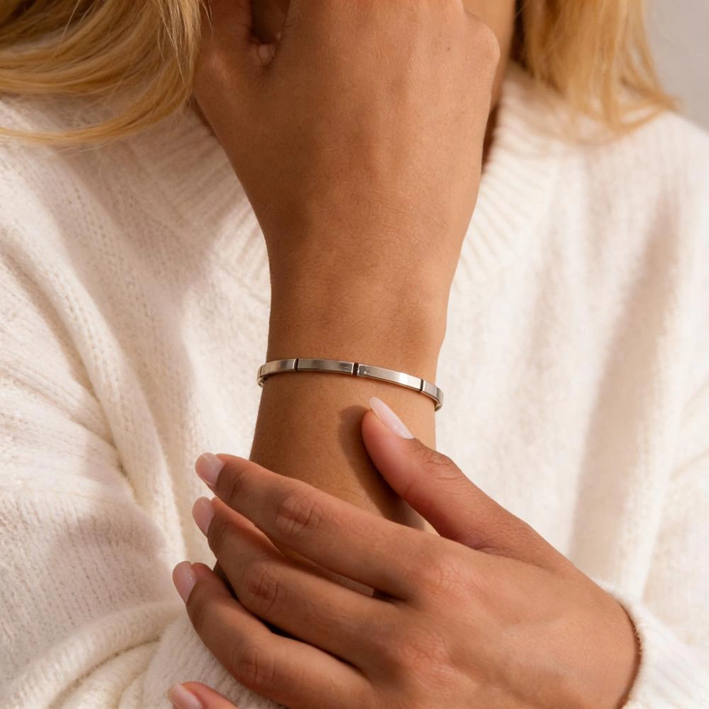 Stainless steel bracelet on an AI model, with clean lines, solid shapes and modern brushed or polished finishes visible on the wrist.