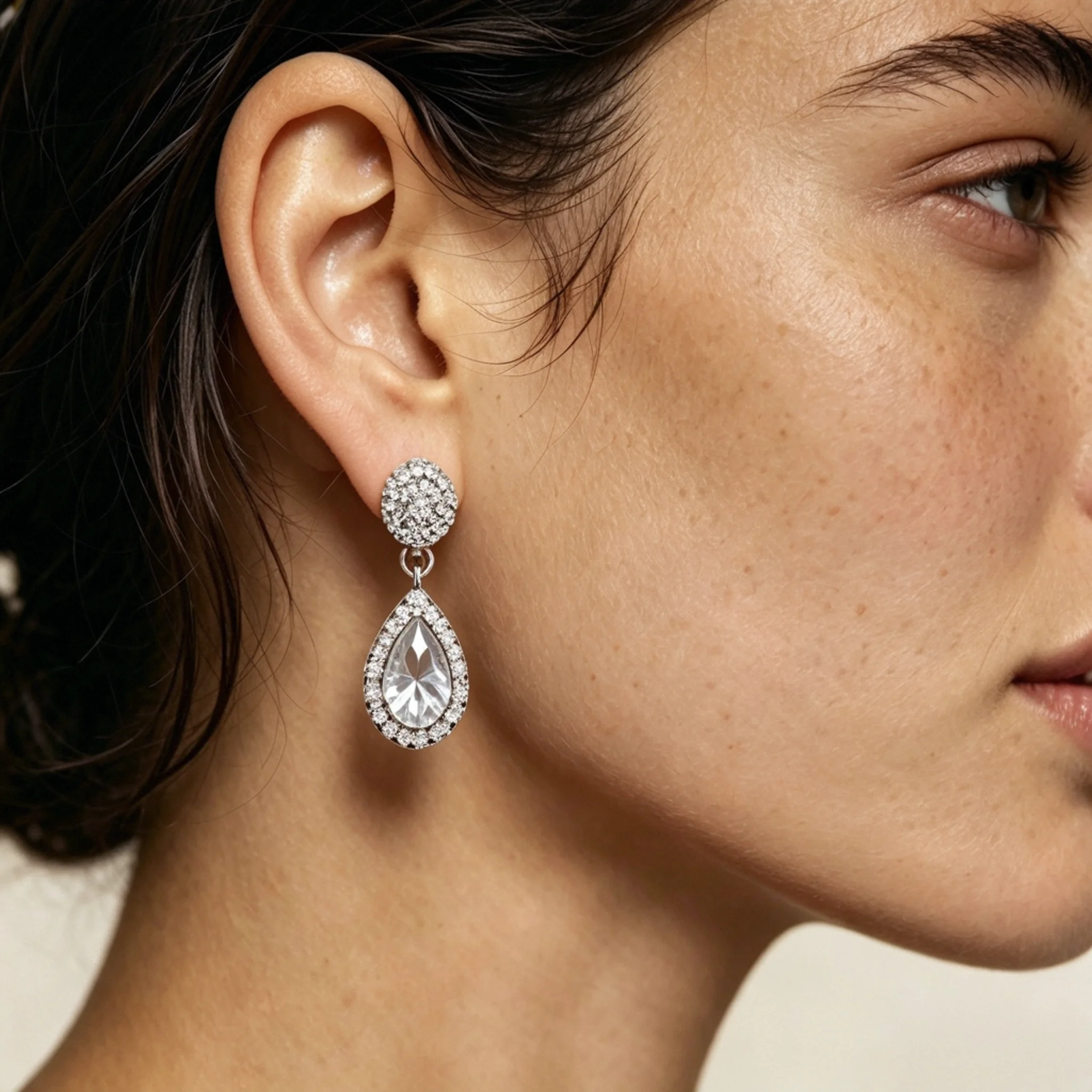 Teardrop diamond earrings shown on a model with visible length, shape, and ear placement